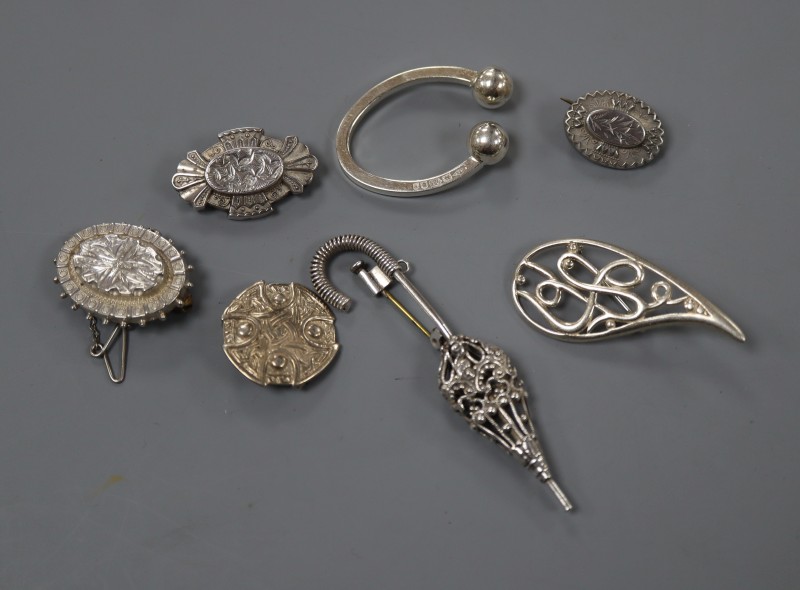 A silver Celtic style brooch and six other silver or white metal items of jewellery.